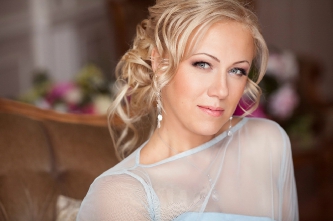 Нежный свадебный макияж для серых глаз и собранная свадебная прическа с низким пучком и локонами для блондинки