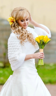 Натуральный свадебный макияж с накладными ресничками и свадебная прическа с локонами на бок, челкой и цветком для блондинки